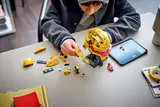 Hands building LEGO Lewis Hamilton helmet.