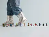 Child walking past LEGO Series 26 minifigures.