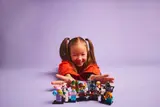 Child reaching for minifigures.