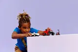 Child playing with LEGO Sonic cars and traffic light.