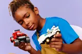 Child holding and inspecting LEGO Sonic cars.