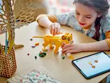 Child building Simba cub with tablet.