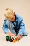 Child playing with Snowplow and minifigure.