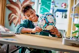 Boy smiling, holding the LEGO Soccer Ball.
