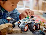 Child placing astronaut in rover.