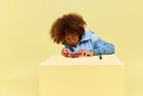 Child playing with car and minifigures.