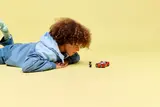 Child observing the car and minifigures.