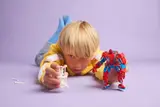 Child playing with Spider-Man Mech and Anti-Venom.