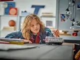 Child playing with LEGO train.