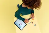 Child building LEGO with digital instructions.