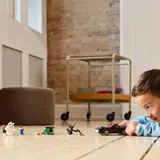 Child playing with LEGO car.
