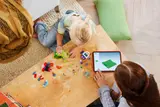 Child building LEGO with digital instructions.