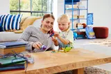 Mother and child playing with LEGO Marvel vehicles.