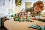 Smiling child playing with LEGO dinosaur.