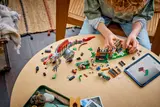 Child building LEGO dinosaur set.