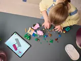 Child building with tablet instructions.