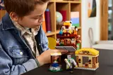 Child holding LEGO Minecraft chicken house.