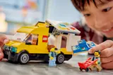 Child playing with LEGO van and minifigures.