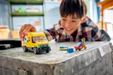 Child playing with closed LEGO van.
