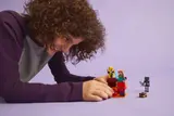 Person playing with LEGO Minecraft set.