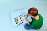 Child building with digital instructions.