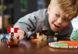 Child reaching for LEGO pirate ship.