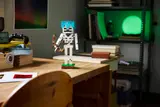 Skeleton on desk with green light.