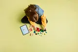 Child building LEGO with digital instructions.