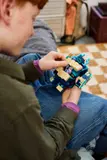 Close-up of hands attaching a piece to the LEGO Warden.