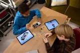 Kids building LEGO DeLorean with tablets.