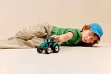 Child playing with LEGO tractor.