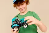 Child happily examining LEGO tractor.