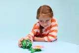 Girl playing with LEGO turtle.