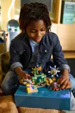 Child interacting with LEGO Minecraft 21598 figures.