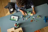 Child building LEGO Minecraft 21598 set.