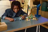 Child playing with LEGO Minecraft 21598 set.
