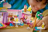 Child interacting with minifigures at cafe.