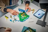 Hands building Vini Jr. LEGO letters.