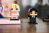 Wednesday and Enid BrickHeadz on a desk.