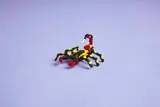 LEGO scorpion on light purple background.