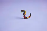 LEGO snake on light purple background.