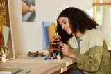 Girl adding Illager to LEGO Minecraft 21272 set.