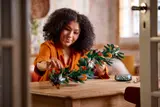 Woman transforming LEGO Holiday Wreath into a garland.