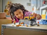Child playing with LEGO City bulldozer.
