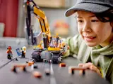 Child playing with LEGO Excavator, close-up.