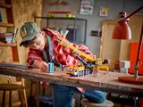 Boy playing with LEGO crane and accessory.