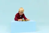 Child playing with LEGO taxi