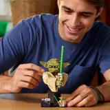 Person building LEGO Yoda bust.