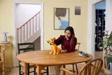 Person interacting with LEGO Young Simba on table.