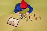 Child building dragon with tablet.